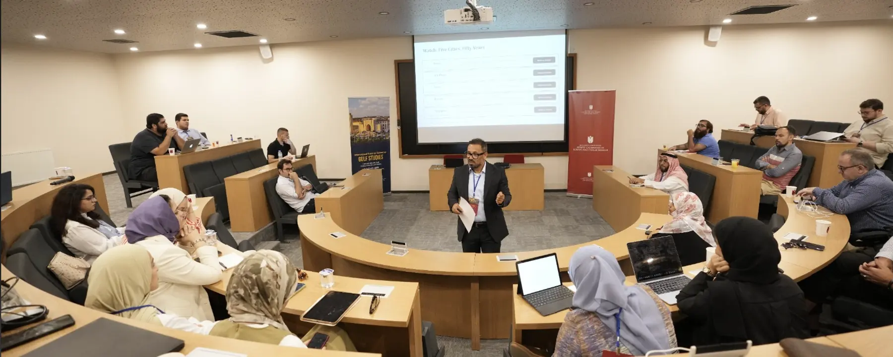 Anis Ben Brik teaching a seminar room of participants at the International Summer School on Gulf Studies